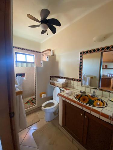 a bathroom with a toilet and a ceiling fan at Hotel Boutique Las Terrazas in Pescadero