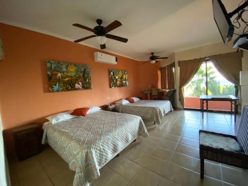 a bedroom with two beds and a ceiling fan at Hotel Boutique Las Terrazas in Pescadero