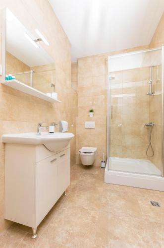 a bathroom with a sink and a shower and a toilet at Apartments and Rooms Adriatic Suites in Šibenik