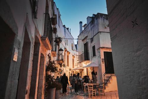 a group of people walking down a narrow street at 1783 Dimora d'Epoca in Locorotondo
