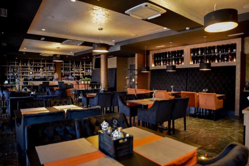 a restaurant with tables and chairs and wine bottles at Hotel Meduza in Senj