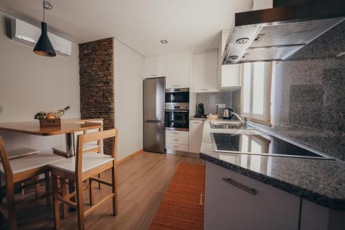 a kitchen with white cabinets and a table and chairs at Ti`Justina Country House in Rossas