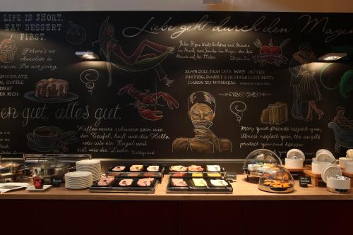 a counter with a menu and a table of food at pentahotel Wiesbaden in Wiesbaden