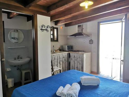 una camera con letto blu e lavandino di ZAGARA appartamenti a Custonaci