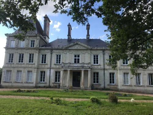 Una vieja mansión con dos chimeneas encima. en Chateau L' Escale en Saint-Herblon