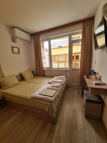 a bedroom with a large bed and a window at Guest Rooms Kostovi in Nesebar