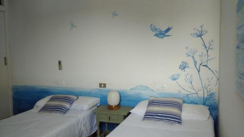 two beds in a room with butterflies on the wall at 4 Vents Cala Galdana in Cala Galdana