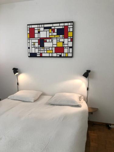 una camera con due letti e un dipinto sul muro di Central 2 bedroom flat in heart of Eaux-vives a Ginevra