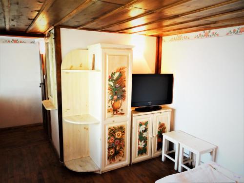 a room with a refrigerator and a tv at Стаи за гости The Old House in Velingrad