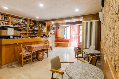 ein Restaurant mit Tischen und Stühlen und eine Bar in der Unterkunft Albergo Speranza in Asiago