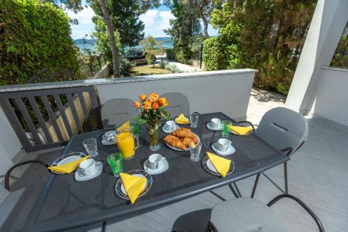 a table with food and drinks on a balcony at Sea Sound Apartments Rea in Sveti Filip i Jakov