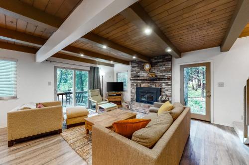 a living room with a couch and a fireplace at Snowpeak Chalet in Camp Connell