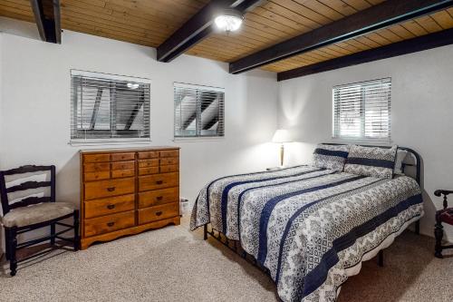a bedroom with a bed and a dresser and a chair at Snowpeak Chalet in Camp Connell