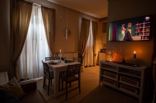 a living room with a table and a television on the wall at Appartamento Antonacci in Monopoli