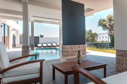 a living room with a table and chairs and a swimming pool at Villa Una in Kotor