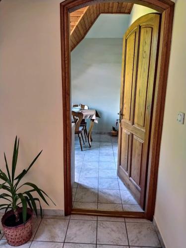 a hallway with an open door with a table in the background at Bodó Ház in Gyenesdiás