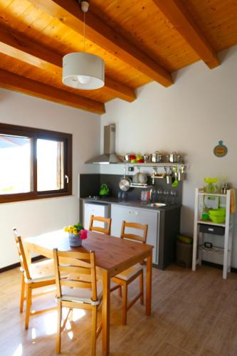 a kitchen with a wooden table and chairs in a room at Cuore Della Valle in Cefalù