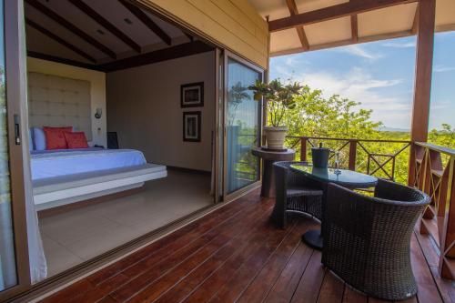 a bedroom with a bed and a balcony with a table at Rancho Humo Estancia in Puerto Humo