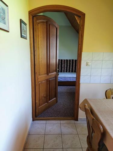 a wooden door in a room with a table at Bodó Ház in Gyenesdiás