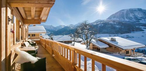 Elle comprend un balcon offrant une vue sur une montagne enneigée. dans l'établissement Chalet Alpaga Location de prestige, à Manigod