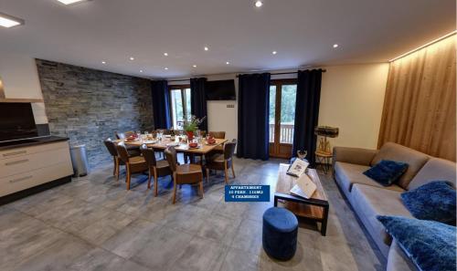 een woonkamer met een tafel en een bank bij Chalet Beausoleil 4 étoiles - prestige - au pied du col de la croix de fer in Saint-Sorlin-dʼArves