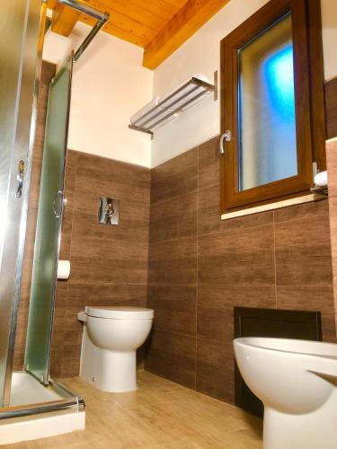a bathroom with a toilet and a glass shower at Cuore Della Valle in Cefalù