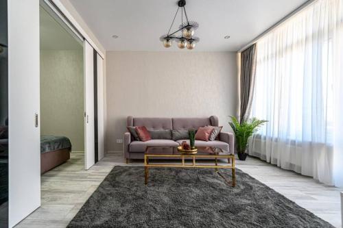 a living room with a couch and a coffee table at Комфортные апартаменты 36 жемчужина in Odesa