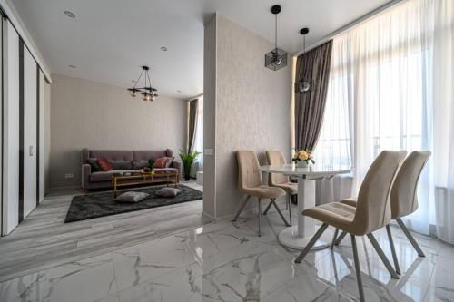 a living room with a table and a couch at Комфортные апартаменты 36 жемчужина in Odesa