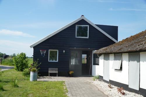 a black and white house with a porch at Groepsverblijf "De Klosse" in Wanneperveen