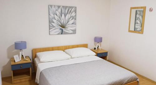 a bedroom with a bed and two night stands with lamps at Apartmani Igor in Makarska
