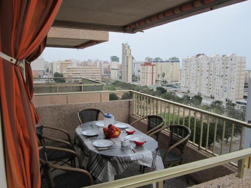 a table on a balcony with a view of a city at Apartamento Jardin II in Gandía