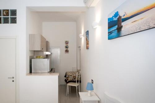a white kitchen with a refrigerator and a table at B&B La Pineta in Orbetello