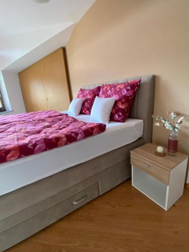 1 dormitorio con 1 cama grande con almohadas rojas en Apartma Bernard, en Radovljica