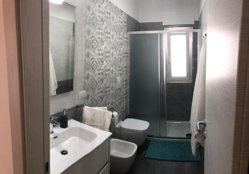a bathroom with a sink and a toilet and a shower at Casa Giorgia Monopoli in Monopoli