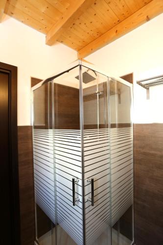 a glass shower in a room with a wooden ceiling at Cuore Della Valle in Cefalù