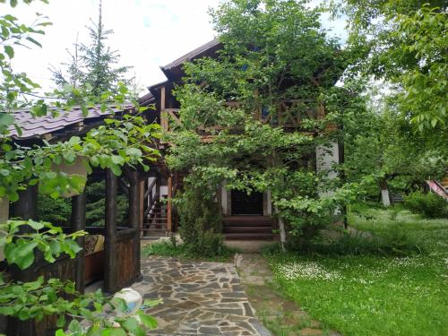 a house with a stone walkway in front of it at Guest House Plai in Yaremche