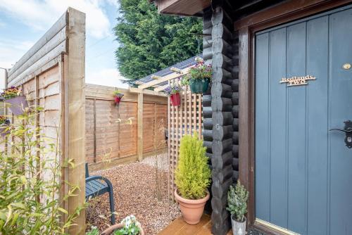 a garden with a fence and a blue door at Redlands Country Lodge Apartments with Hot Tubs in Ladybank