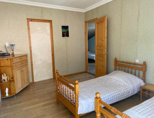 a bedroom with a bed and a dresser and a mirror at Emma's Guesthouse in Borjomi in Borjomi