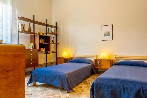 ein Schlafzimmer mit 2 Betten und einem Bücherregal in der Unterkunft La Casa di Elvira in Giardini-Naxos