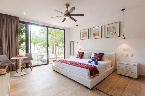 Un dormitorio con una cama y un ventilador de techo. en Mexican style studio with free Spa & Gym access, en Tulum