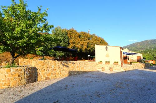 a stone wall with a tree and a building at Cuore Della Valle in Cefalù