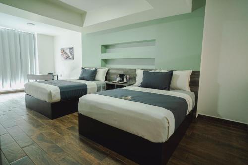 a hotel room with two beds in a room at Real Naviero Hotel Ejecutivo in Manzanillo