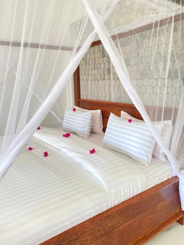 two beds in a room with flowers on them at Habibis Bottle House in Nungwi