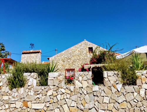 a stone wall with a building behind a stone fence at Imperio de Memorias - Casa de Campo in Vale Bordalo