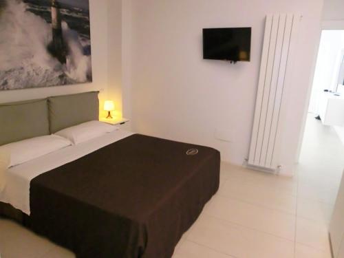 a bedroom with a bed and a tv on the wall at Orchidea Beach in Civitanova Marche