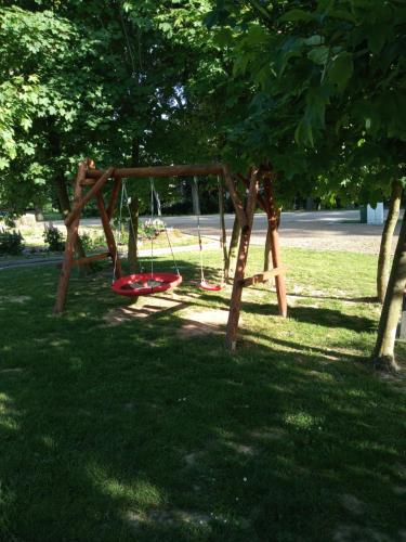 a swing set in the shade of a tree at Gajówka in Wünschelburg