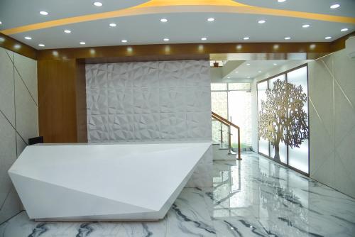 a lobby with a white counter and marble floors at The Castle Inn in Dhaka