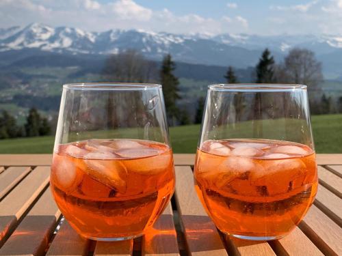 two glasses of juice sitting on a wooden table at Frühstückspension Bilgeri in Sulzberg