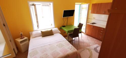 um pequeno quarto com uma cama e uma cozinha em Apartment Palada em Baska