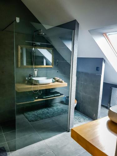 a bathroom with a sink and a glass shower at Tűztorony apartman in Veszprém